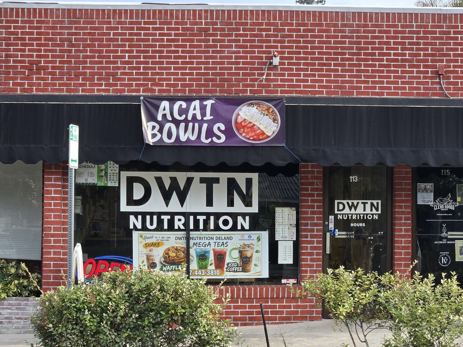 Brick storefront of DWTN Nutrition with an Acai Bowls banner over the awning in downtown DeLand.