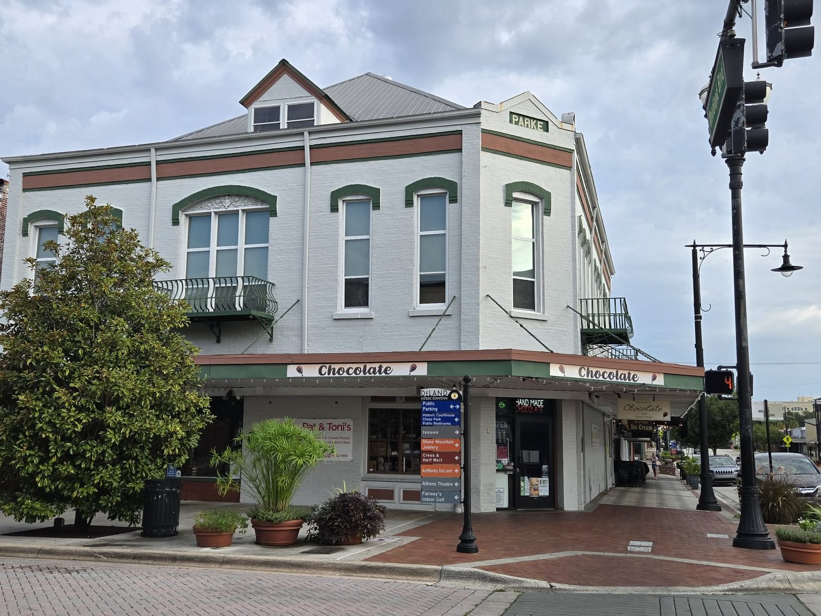 Corner Parke building with Pat and Toni's chocolate shop and a downtown wayfinding sign in downtown DeLand.
