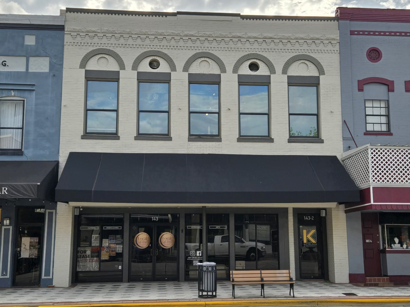 White brick storefront with arched upper windows and Local Style House signage in downtown DeLand.