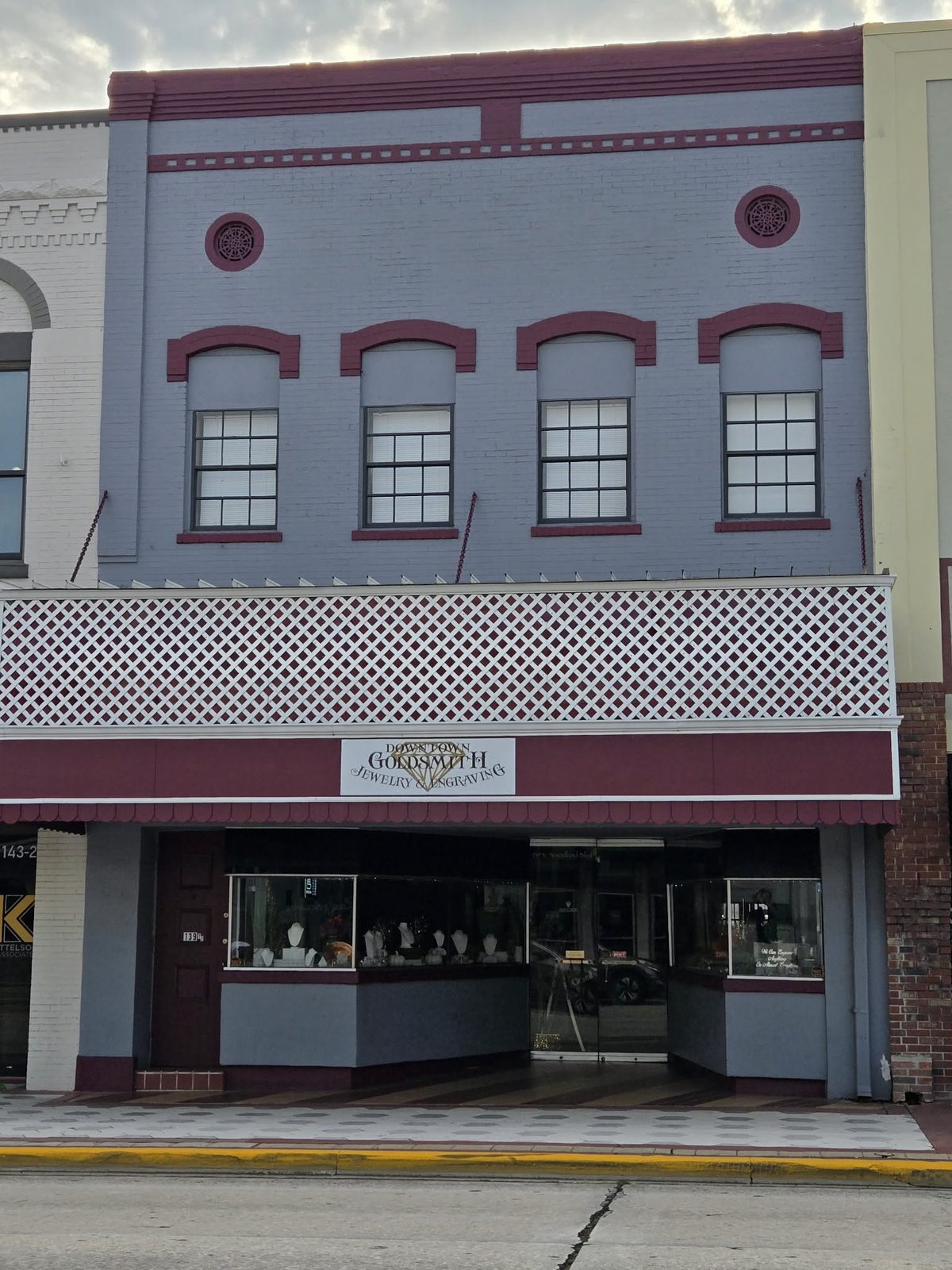 Gray and maroon building with Downtown Goldsmith jewelry and engraving shop in downtown DeLand.