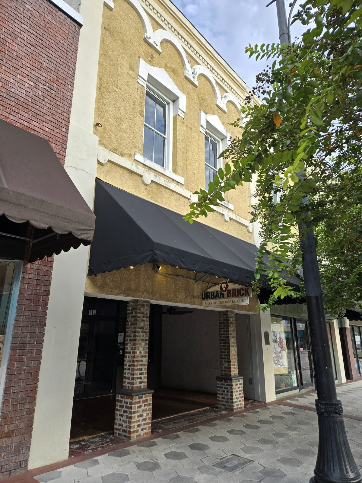 Storefront of Urban Brick Modern Italian Kitchen under a black awning in downtown DeLand.