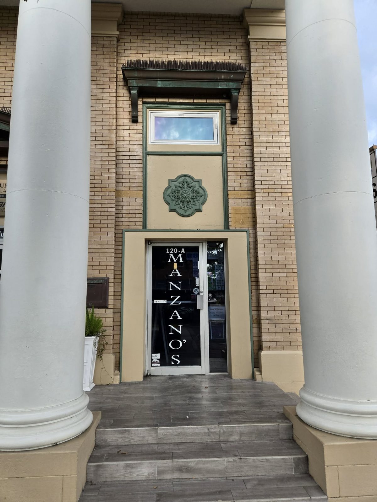 Entrance to Manzano's Deli between two white columns at 120-A in downtown DeLand.