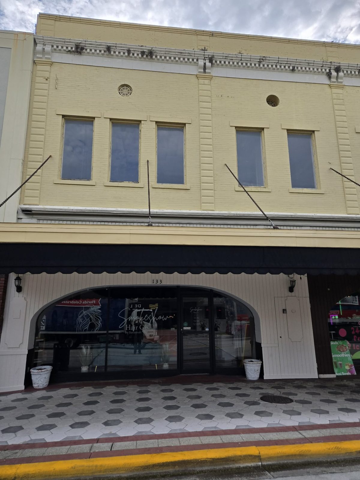 Arched glass storefront for Smokeshow Hair Co. salon in downtown DeLand.